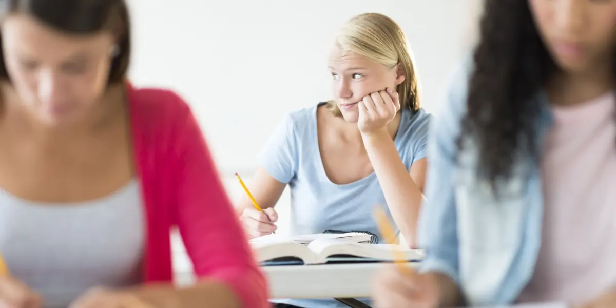 Adults concentrate on written work in a classroom.