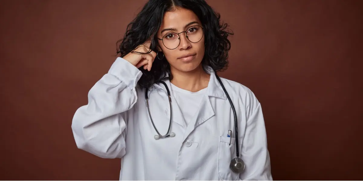 A healthcare professional stands in a bright clinical setting.