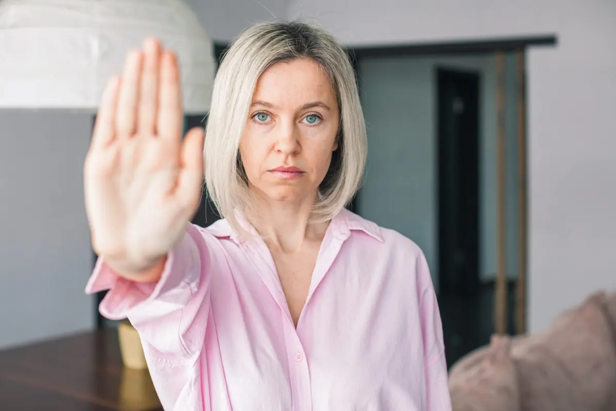 A woman holds up her hand during a conversation.