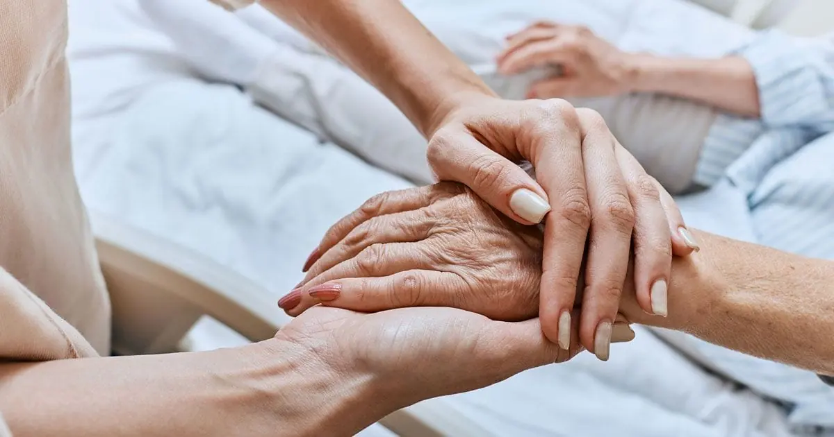 Several people rest their hands together in support.