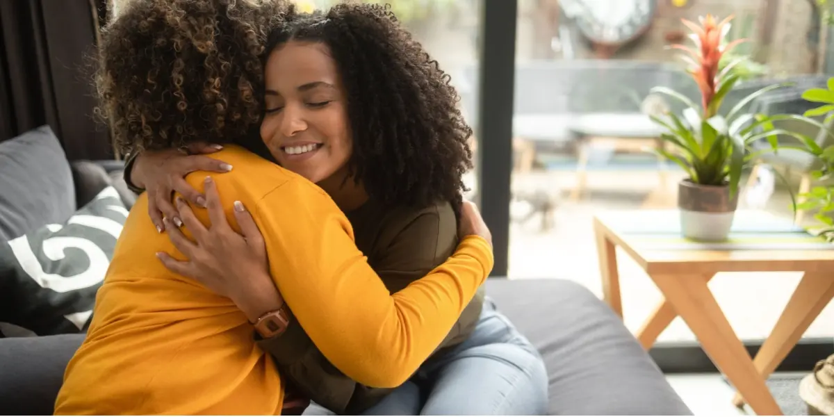 Two women share a reassuring hug.