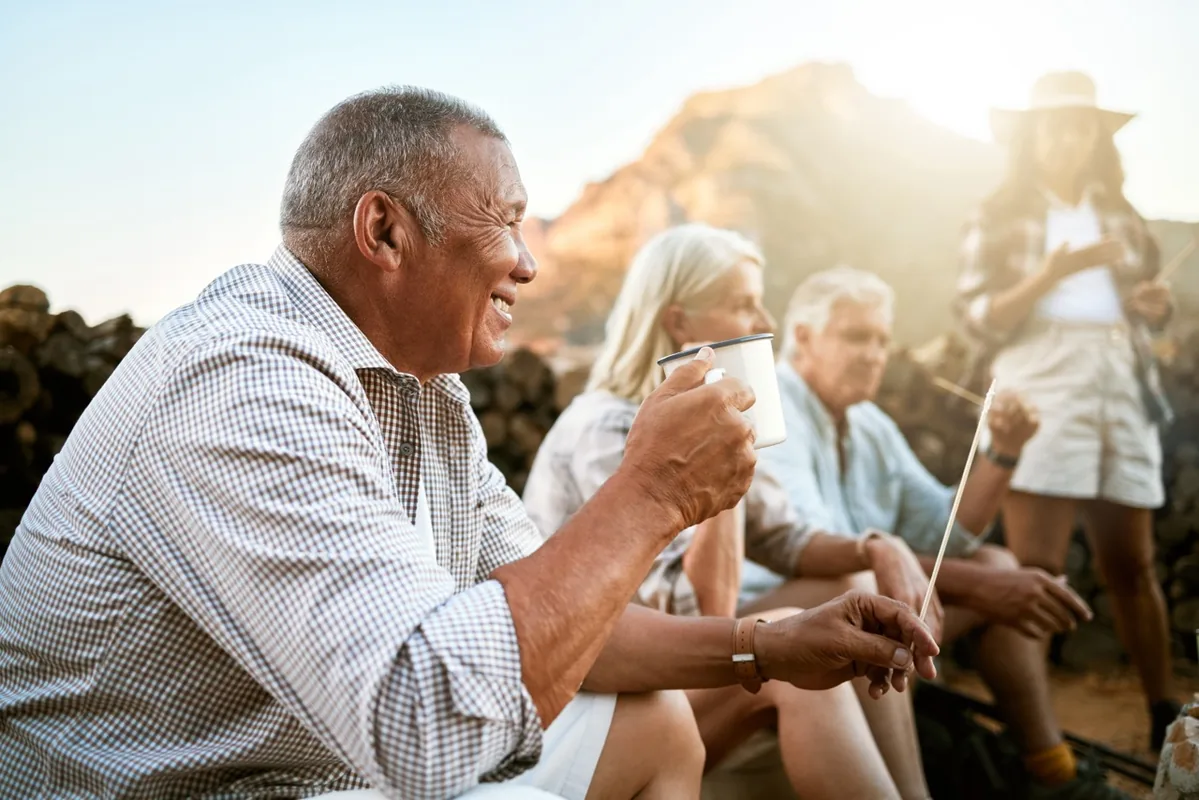 Older adults laugh and talk together outdoors.