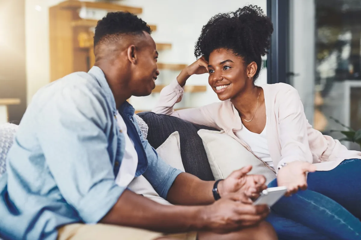A doctor and another adult smile during a friendly conversation.