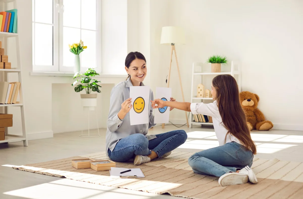 An adult and child practice breathing together while sitting on the floor.