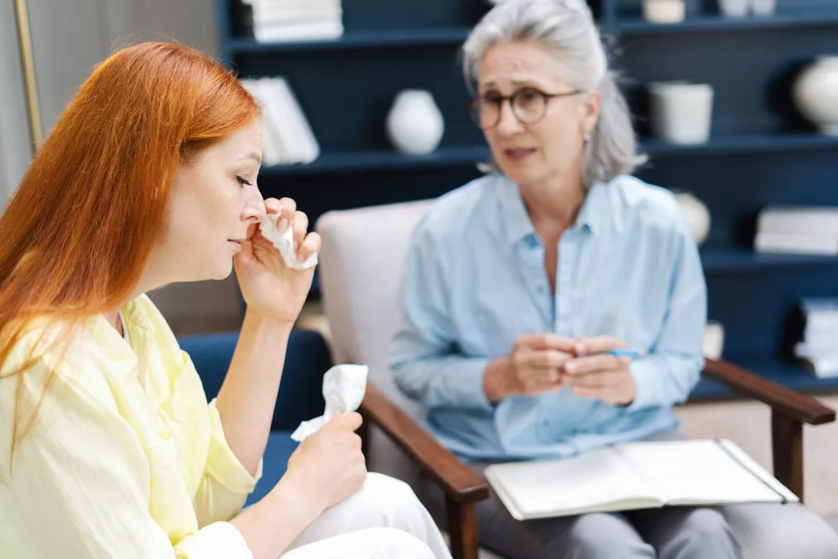 A healthcare professional explains a medicine bottle to a patient.