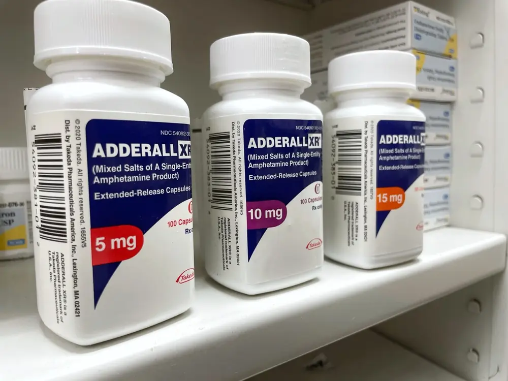 Prescription medicine containers stand beside one another.