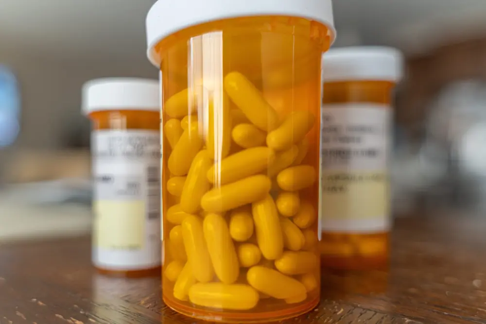 An orange prescription bottle contains tablets.