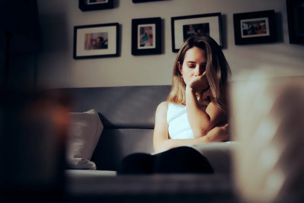 A woman rests beside a window.