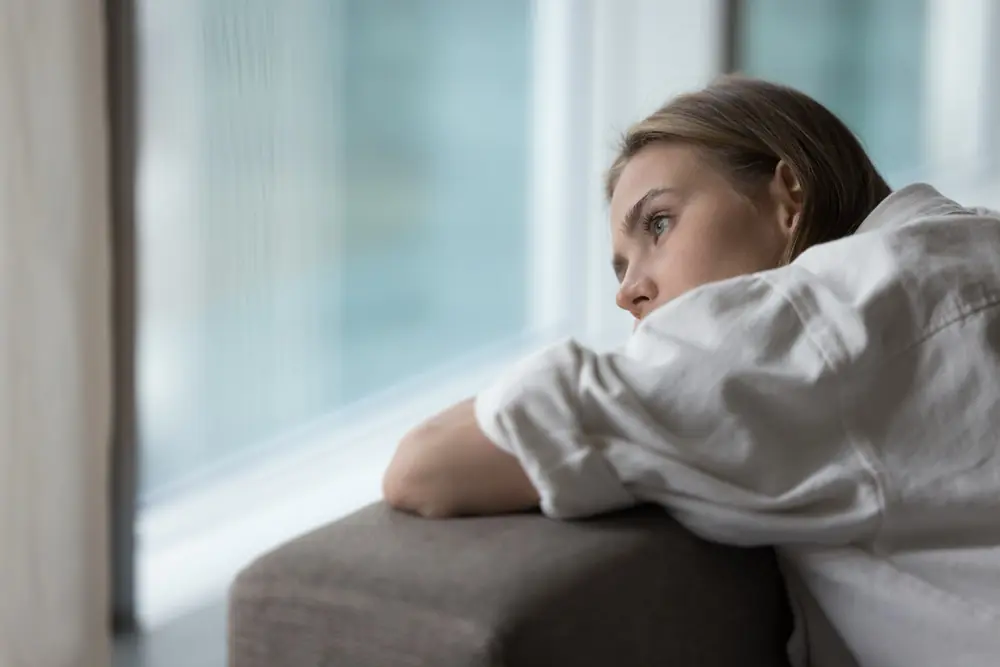 A woman looks out through a window.